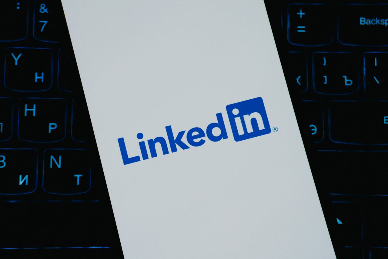 about-01 Close-up of LinkedIn logo on smartphone screen, with keyboard background.